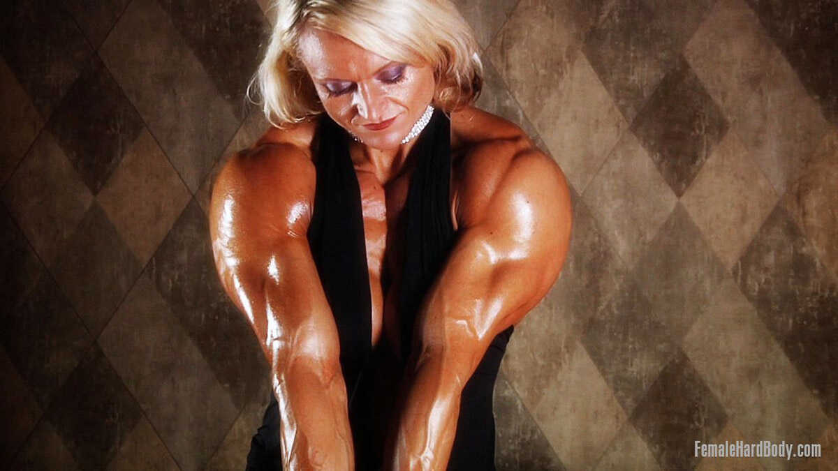 Middle-aged bodybuilder Brigita Brezovac flexes in a plunging black dress