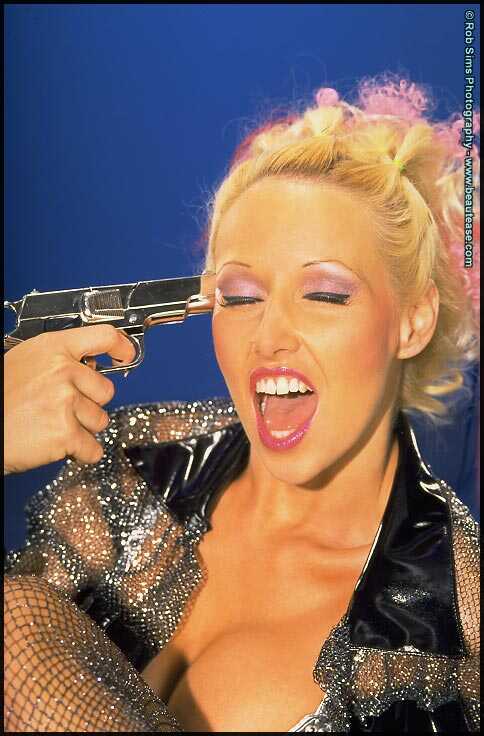 Sexy blonde Chrissy Mountjoy licks a gun before freeing her enhanced tits - Chrissy Mountjoy