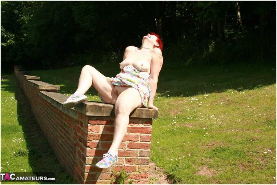 Older redhead Valgasmic Exposed gets totally naked in a public park