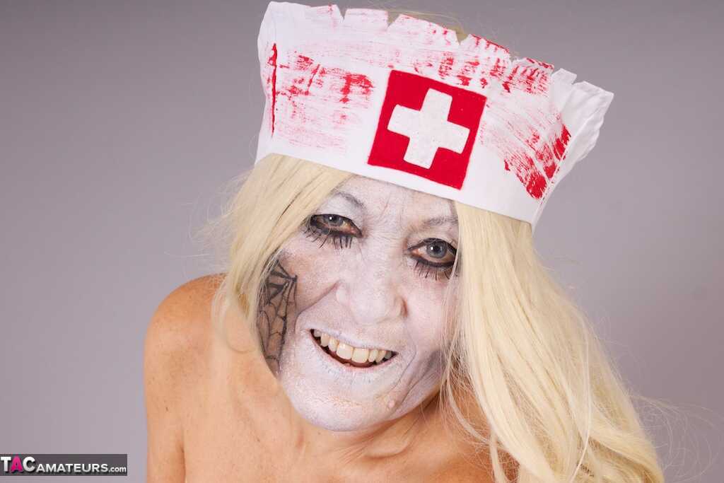 Old blonde amateur Savana removes a nurse uniform during a cosplay scene - Savana