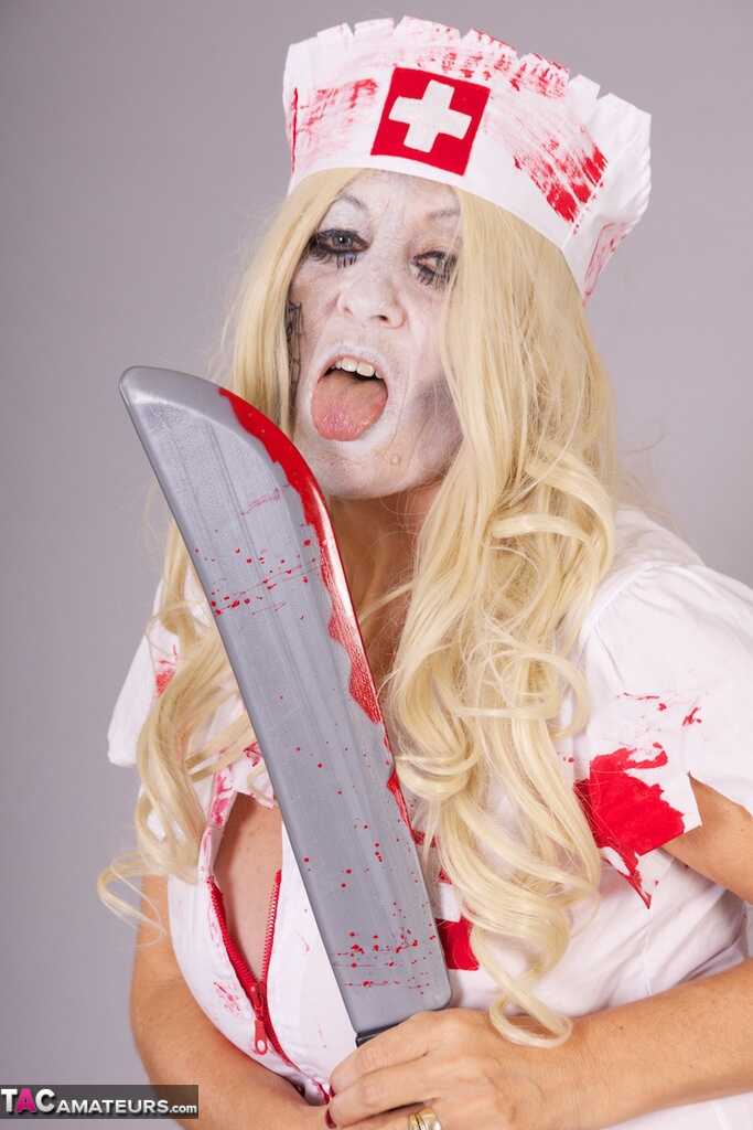Old blonde amateur Savana removes a nurse uniform during a cosplay scene - Savana