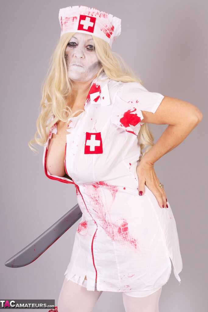Old blonde amateur Savana removes a nurse uniform during a cosplay scene - Savana