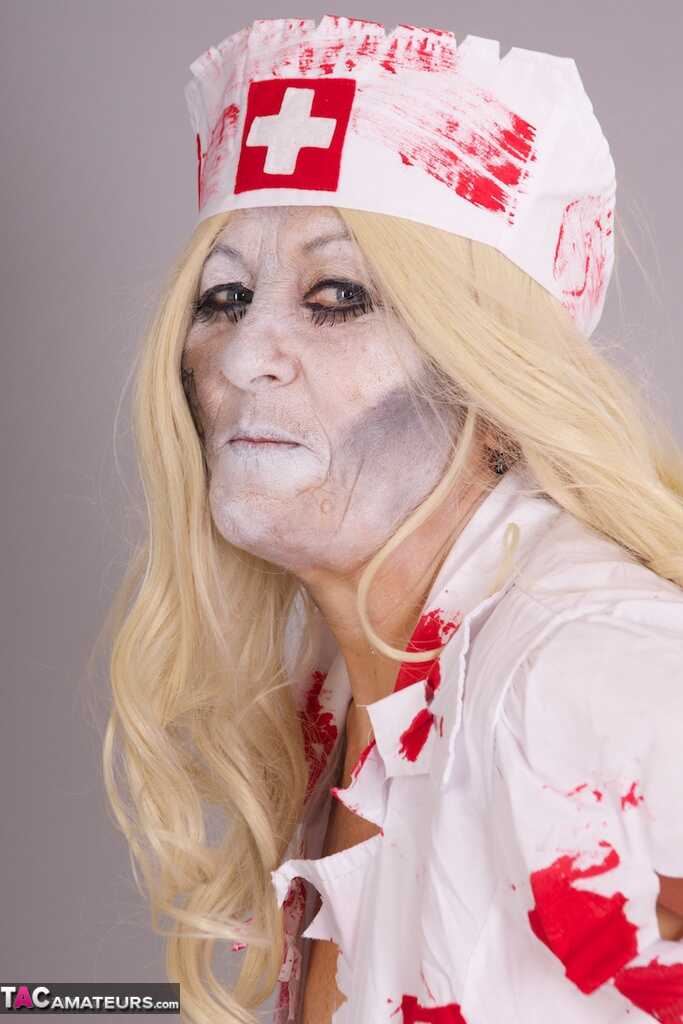 Old blonde amateur Savana removes a nurse uniform during a cosplay scene - Savana