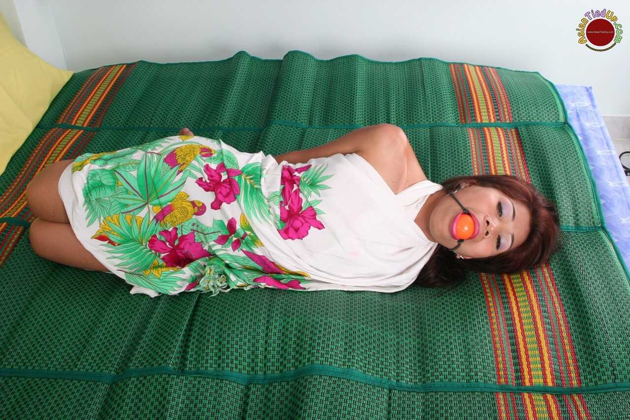 Ball-Gagged Asian Beauty Hogtied and Helpless on a Bed in a Dress with Perfect Feet - 