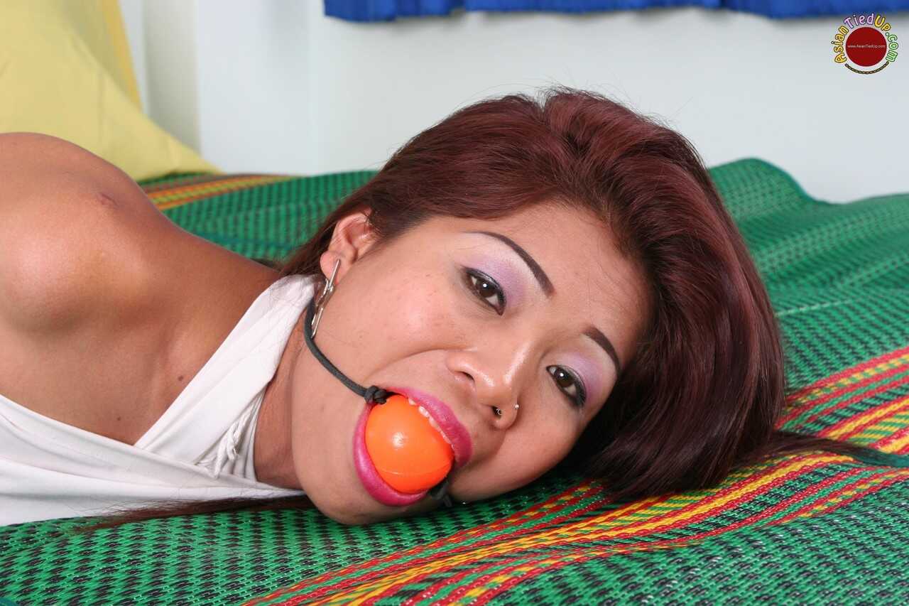 Ball-Gagged Asian Beauty Hogtied and Helpless on a Bed in a Dress with Perfect Feet - 