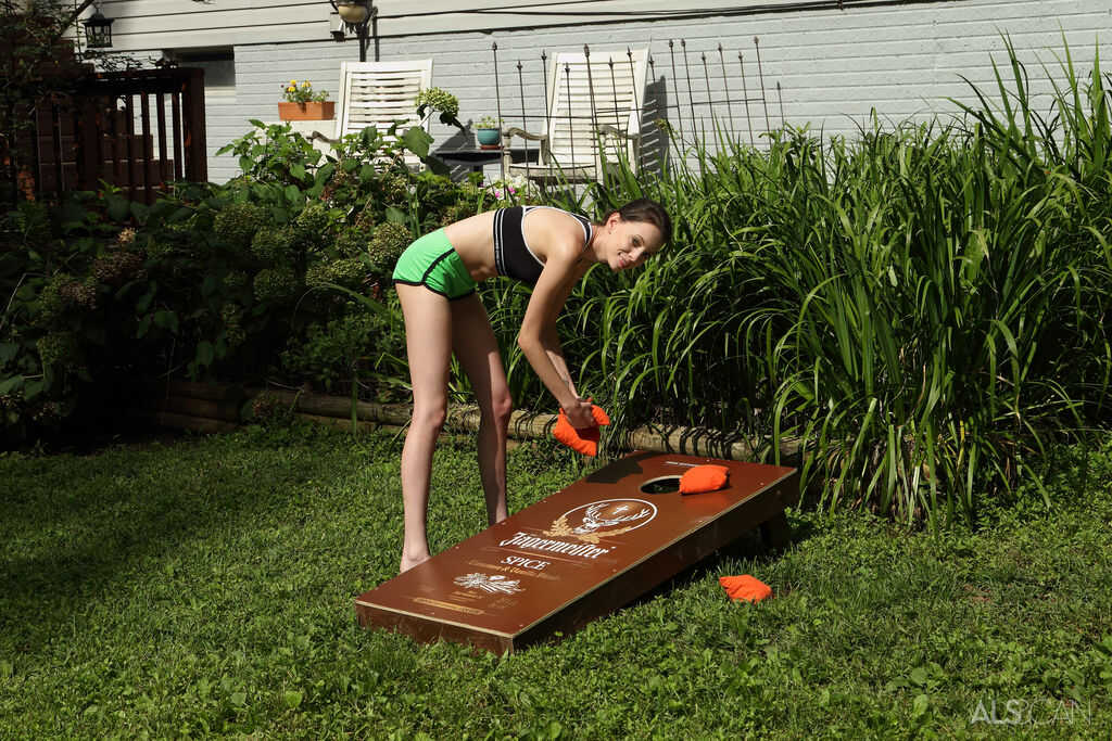 Slender brunette teen Aria Haze dildos her tight pussy on a bean bag toss, as she shows off her thigh gap and flat chest in an outdoor setting.