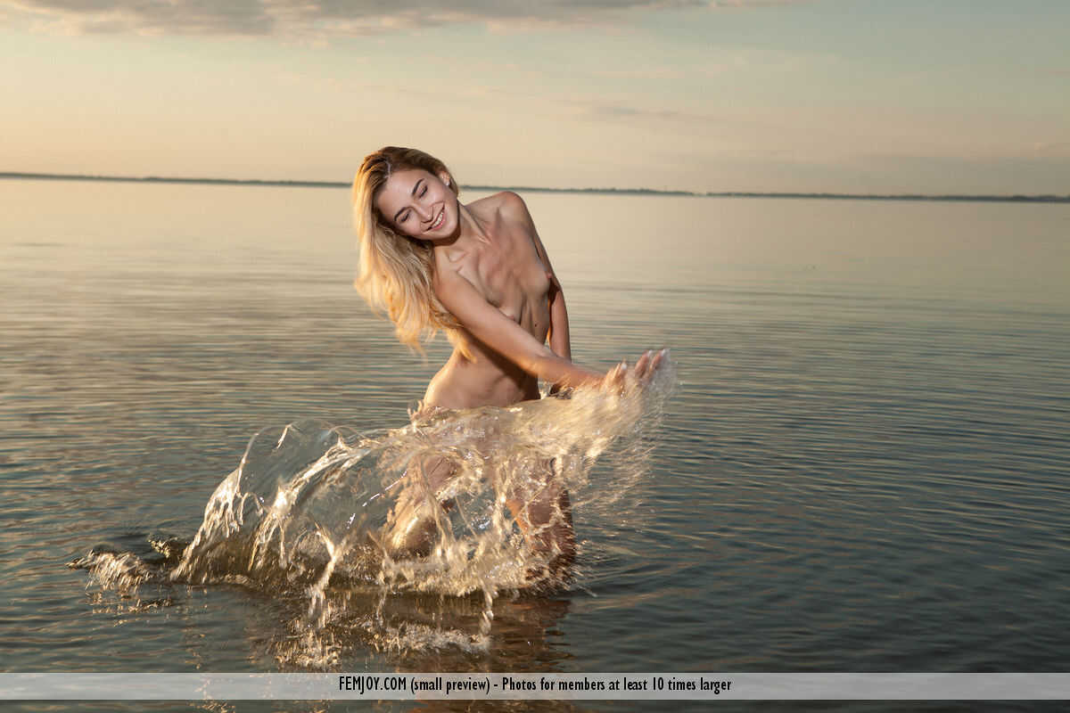 Blonde teen Davina C gets soaking wet and nude in a swimming pool