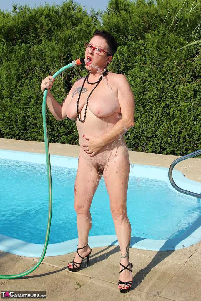 Naked old woman Mary Bitch wets her pierced bush with garden hose beside pool   Gardening Granny Gets Soaked in the Pool! ...