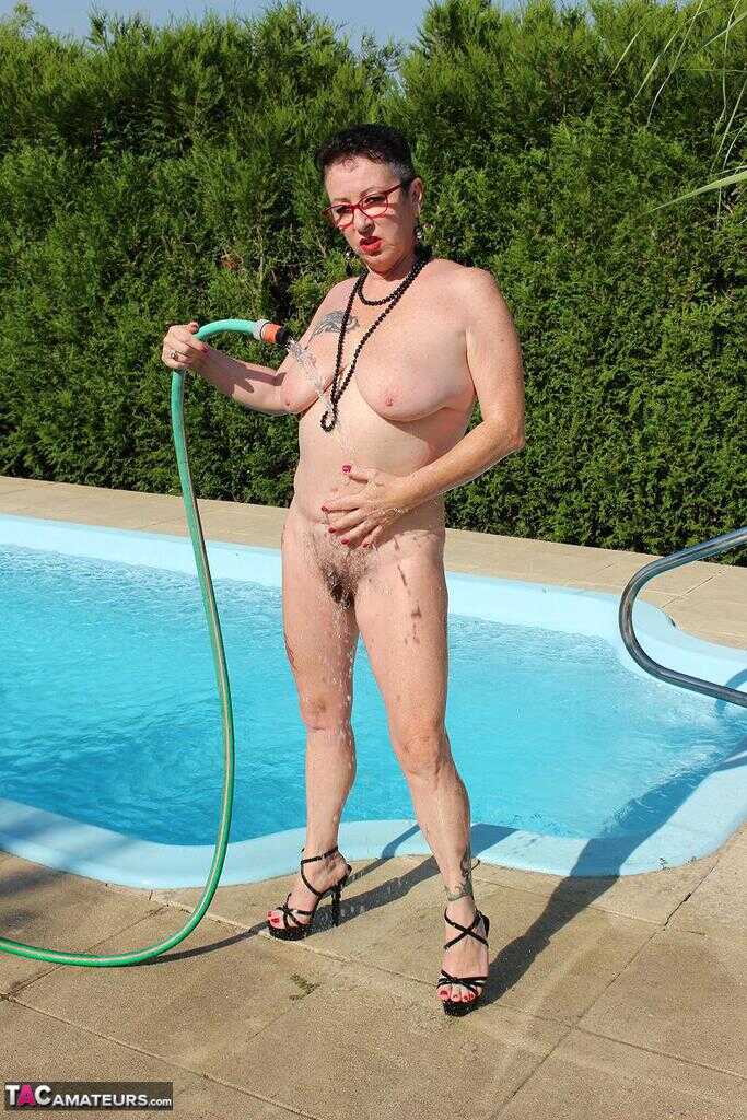 Naked old woman Mary Bitch wets her pierced bush with garden hose beside pool   Gardening Granny Gets Soaked in the Pool! ...