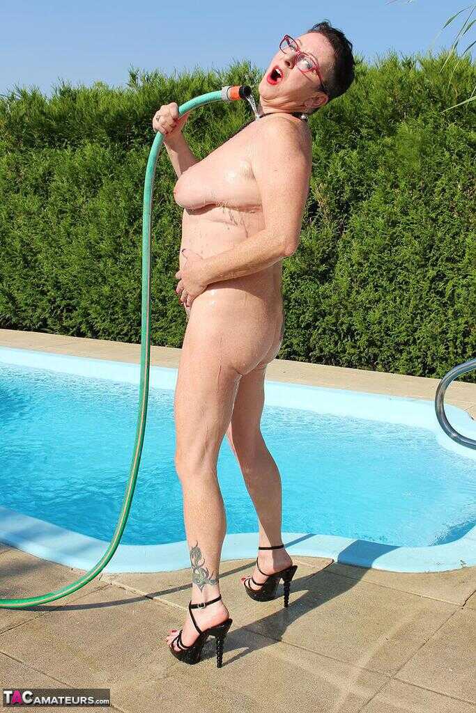 Naked old woman Mary Bitch wets her pierced bush with garden hose beside pool   Gardening Granny Gets Soaked in the Pool! ...