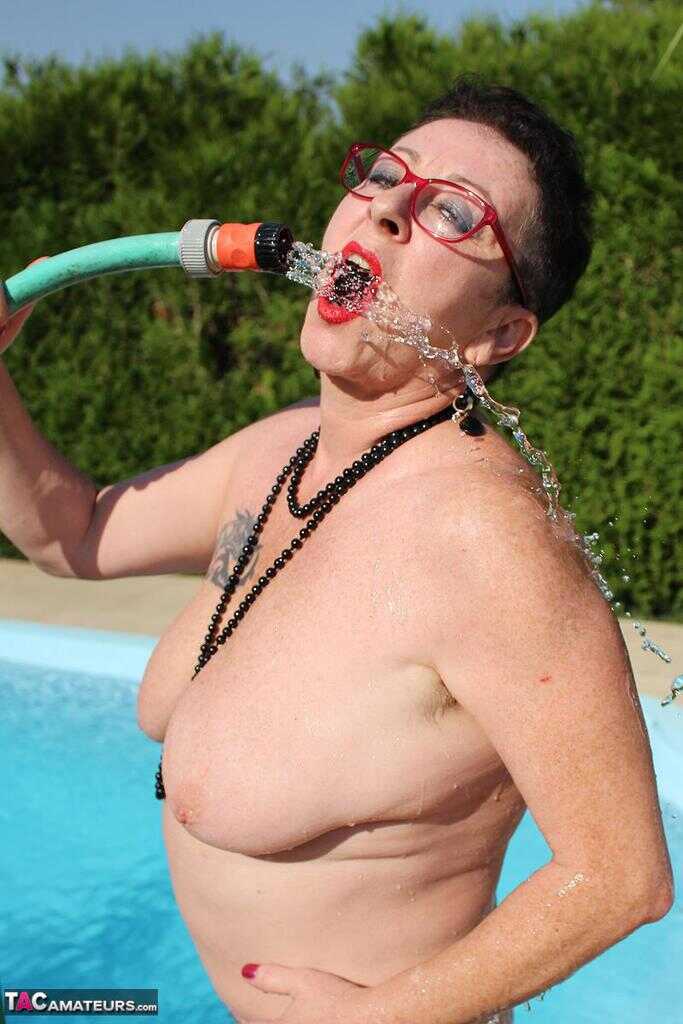 Naked old woman Mary Bitch wets her pierced bush with garden hose beside pool   Gardening Granny Gets Soaked in the Pool! ...