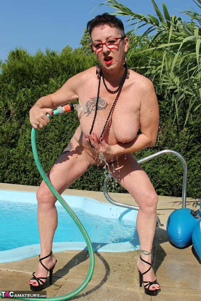 Naked old woman Mary Bitch wets her pierced bush with garden hose beside pool   Gardening Granny Gets Soaked in the Pool! ...