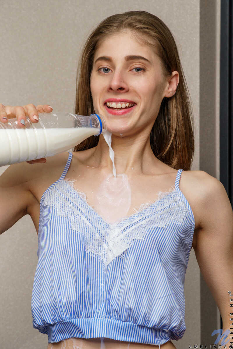 Slender brunette Amelinda's super skinny body on display as she pours a litre of milk over her small tits and bald tw...