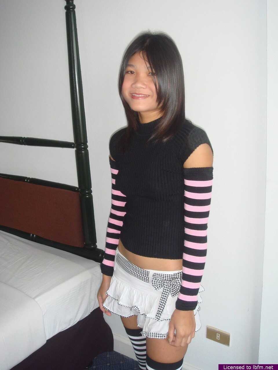 Young Asian Girl's Tight Pussy Exposed as She Disrobes to Arm Socks and Thigh Highs - 
