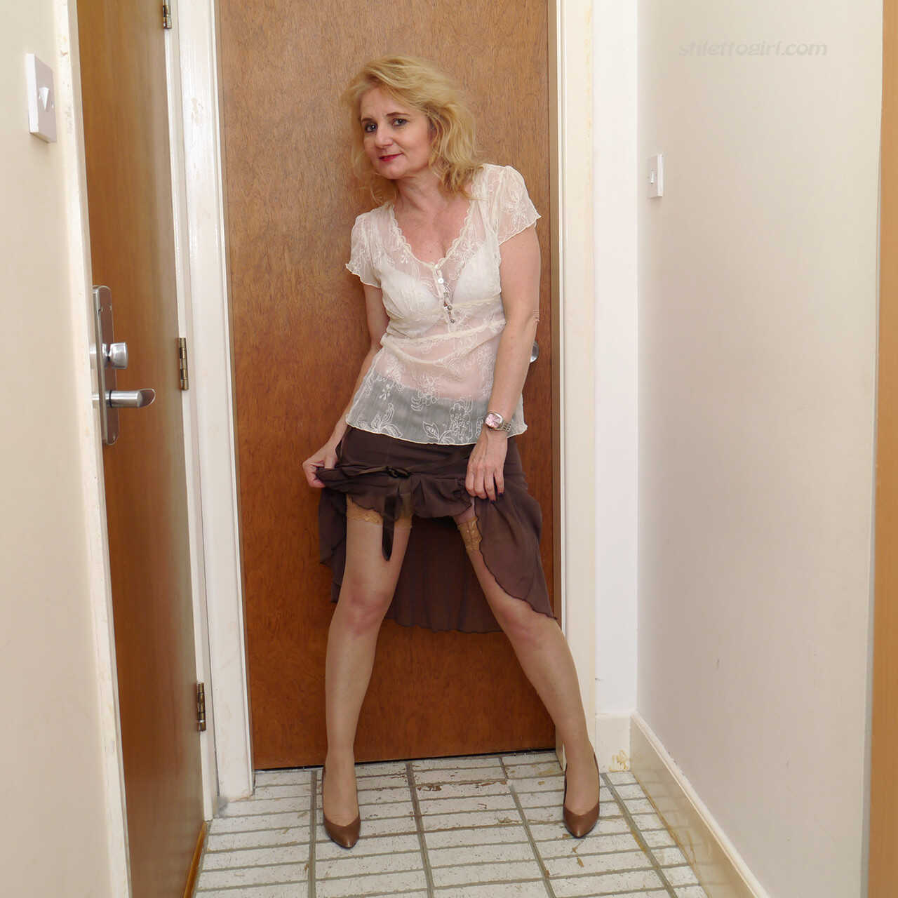 Llaria's Mature Stocking Tease: A Blonde Bombshell's Legs in Heels and Skirt - Llaria