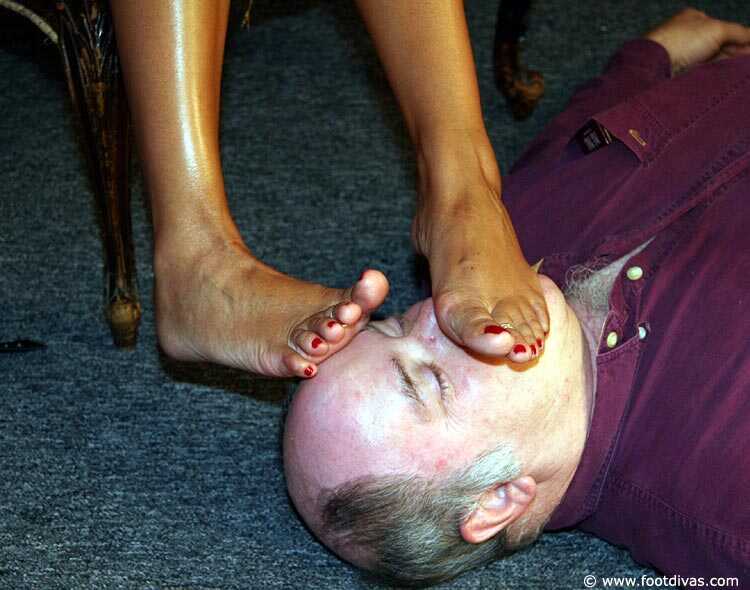 Caucasian female rubs her feet all over an old man's face - 
