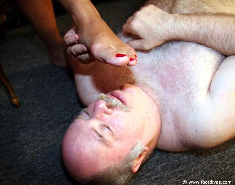 Caucasian female rubs her feet all over an old man's face - 