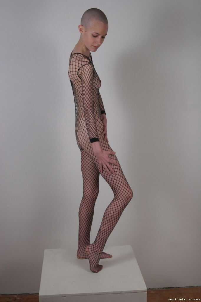 Shaved Head Kate Poses in Fishnet Bodystocking