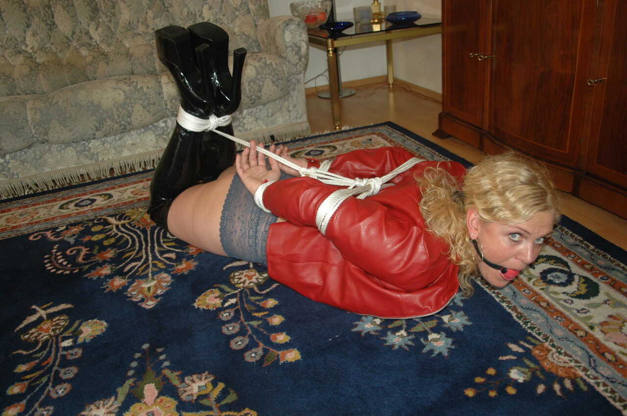 Blonde submissive enjoys BDSM playtime in her red lingerie while hogtied with a ball gag in place