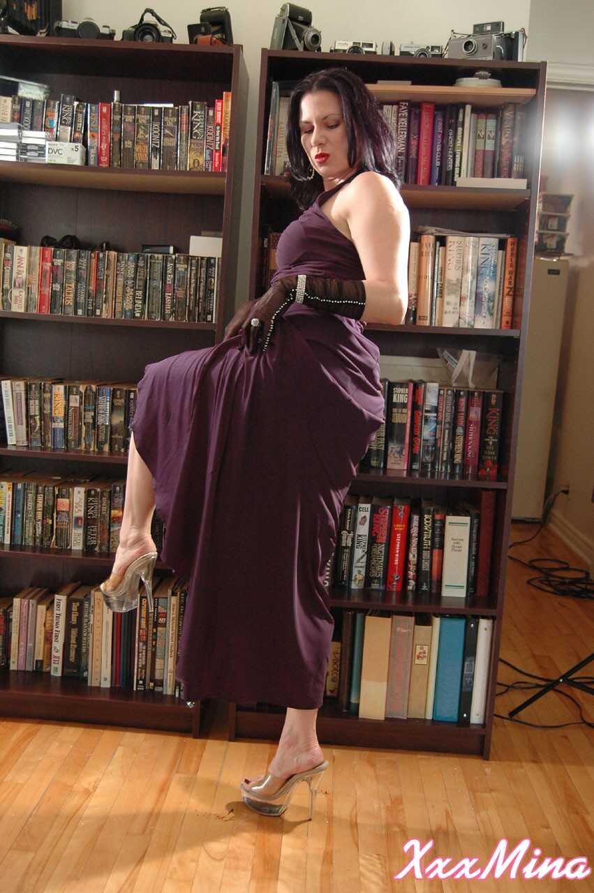 Mature Mina Gorey strips naked in gloves and heels afore a bookcase to show off her sexy small tits! - Mina Gorey