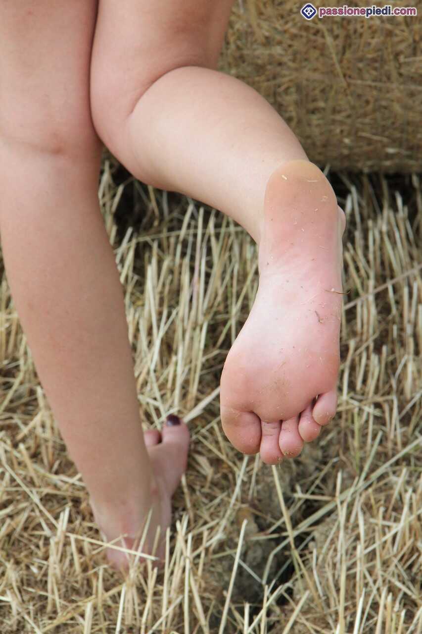 Redhead Thena Poses with Her Bare Feet Next to a Round Bale of Hay A Nude Rural Adventure - Thena