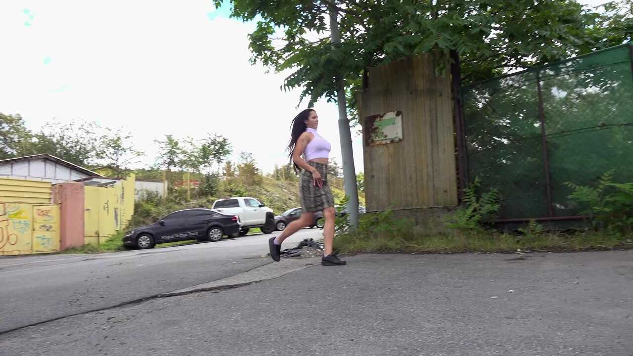 Distressed Isabel Dark takes a public pee on the paved roadway, no panties and tattooed bald pussy on display