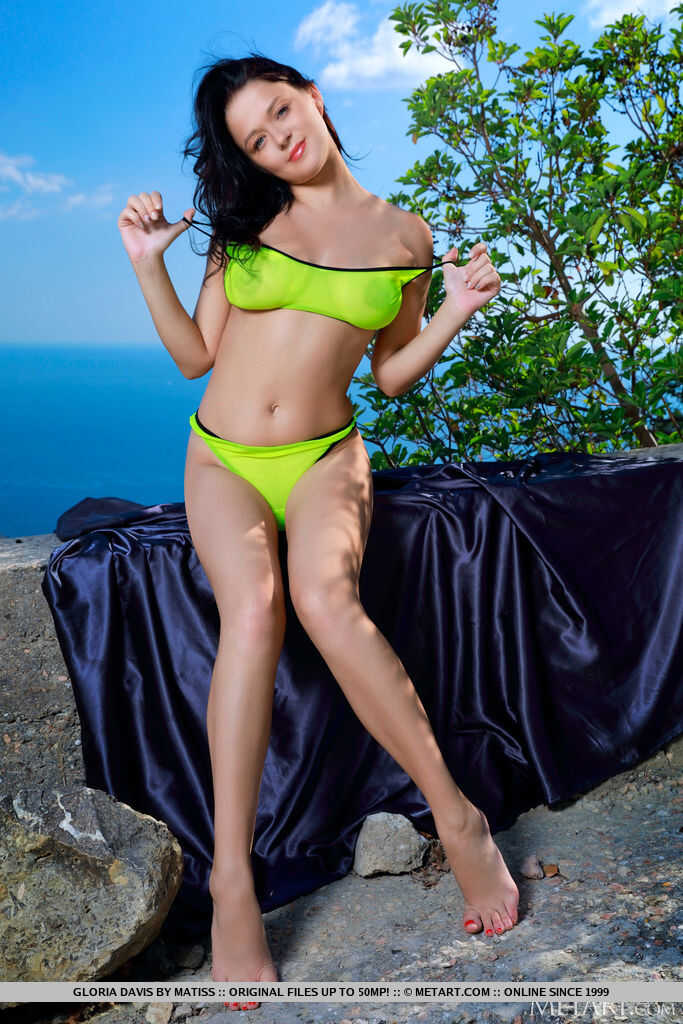 Naughty brunette teen Gloria Davis strips naked and exposes her shaved pussy on a seaside cliff - Gloria Davis