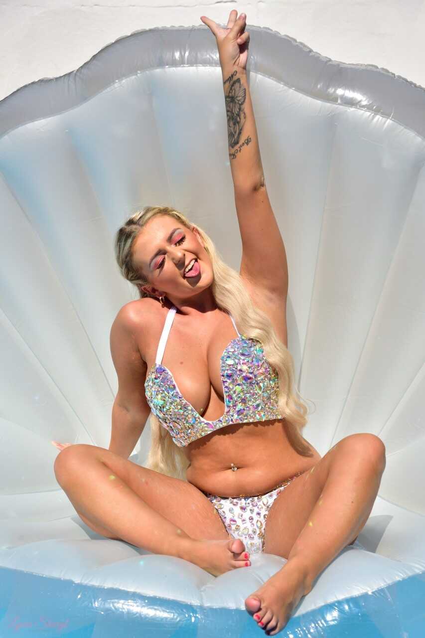 Blonde British teen Lycia Sharyl unleashes her great tits while in a pool, as she shows off her perfect natural tits in a micro bikini