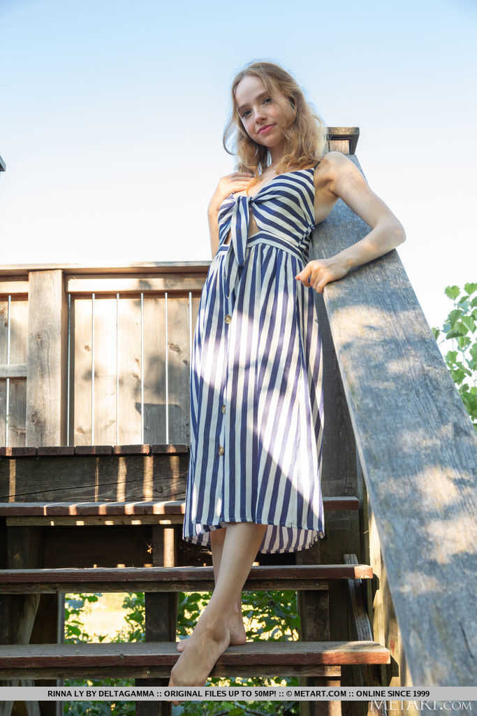 Beautiful blonde teen Rinna Ly strips off her dress to go nude on deck stairs in the great outdoors - Rinna Ly