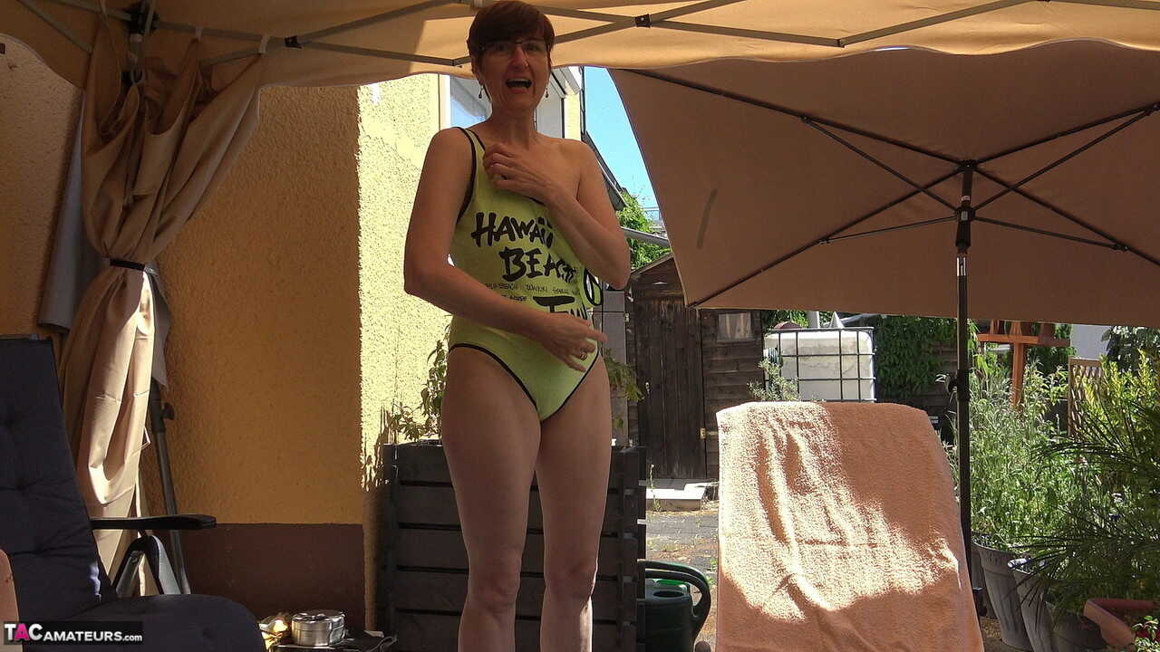 Amateur Hotmilf strips down on a patio lounge chair, showing off her saggy tits and shaved pussy. - 