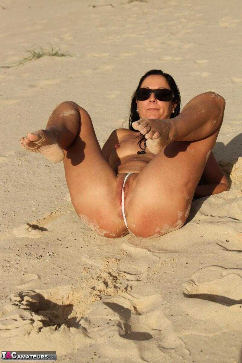 Topless MILF Roxeanne slides her thong aside to show her pussy on a beach 2: MILF Bikini Beach MILF Amateur