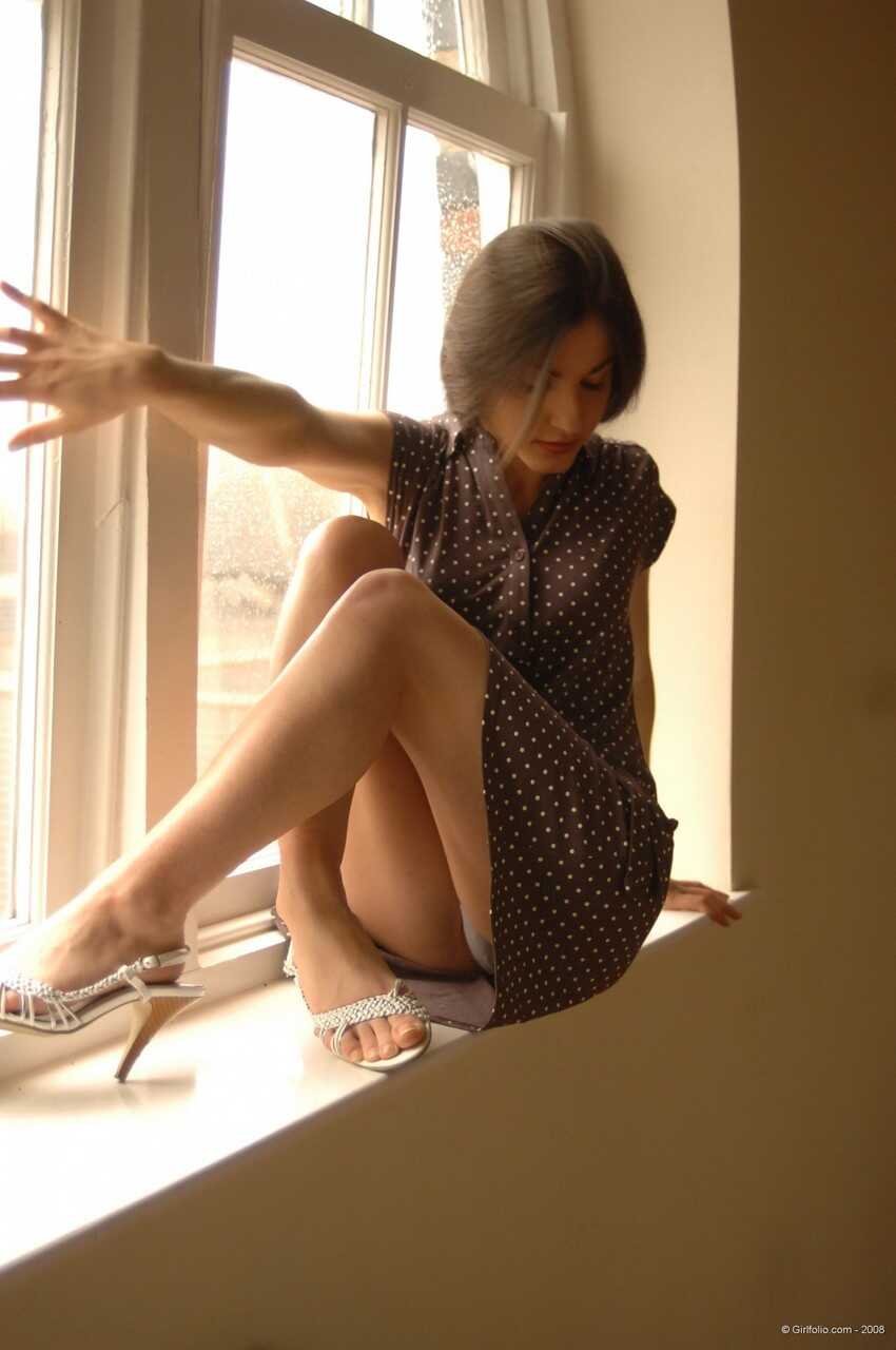 Sexy Mature Woman Poses Seductively In Front Of A Window While Slipping Off Her Dress And Underthings - 