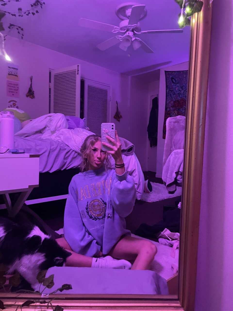 Skinny OnlyFans model Blondie Alexis poses provocatively in a solo mirror selfie, teasing her nerdy glasses-wearing follow...