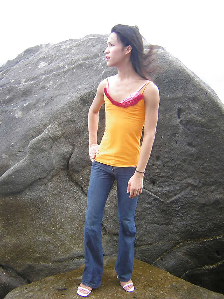 Skinny Asian shemale Ho, outdoors and in the open, shows off her long and slender legs while masturbating with a huge cock...