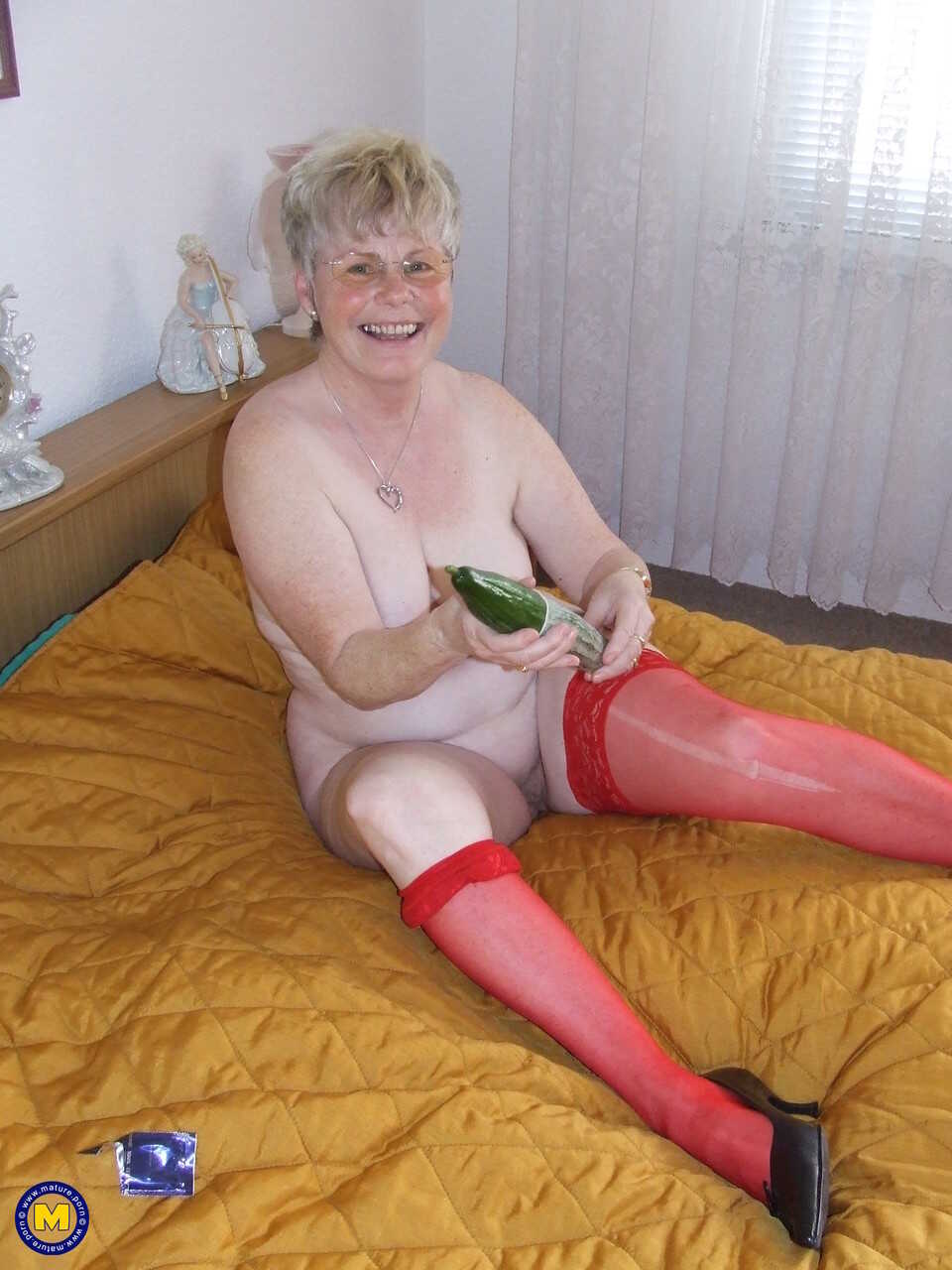 Blonde granny with huge juggs Petra plays with a cucumber in red lingerie - Petra