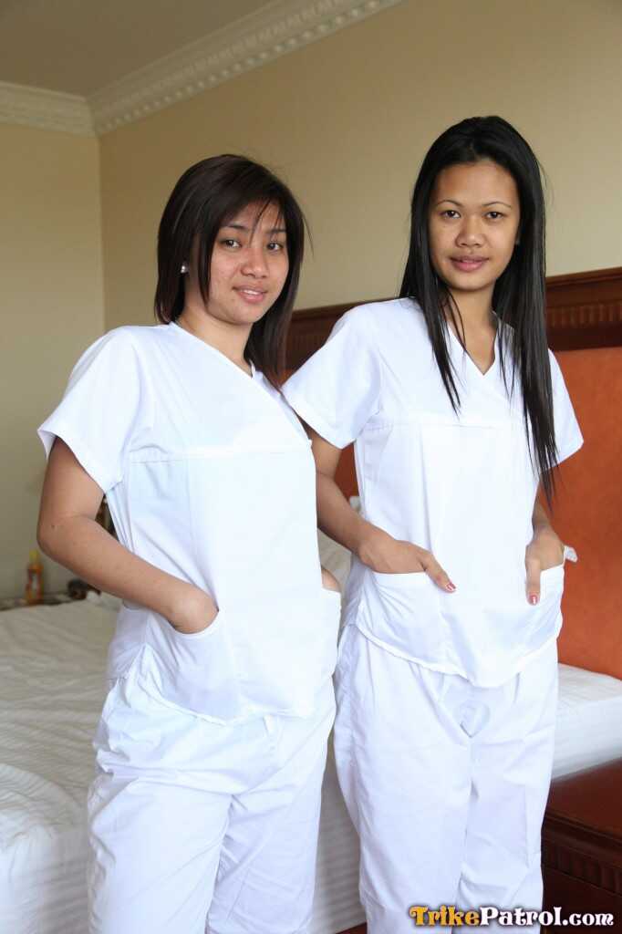 Lusty Filipina Nurses Joanna and Joy Pose on the Bed in Their White Uniforms As The Asian Beauties Explore Each Other&#039...