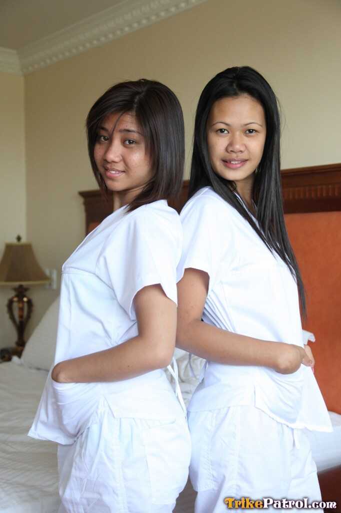 Lusty Filipina Nurses Joanna and Joy Pose on the Bed in Their White Uniforms As The Asian Beauties Explore Each Other&#039...