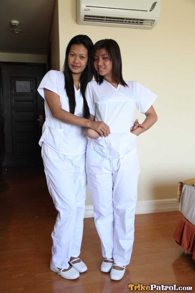 Lusty Filipina Nurses Joanna and Joy Pose on the Bed in Their White Uniforms As The Asian Beauties Explore Each Other&#039...
