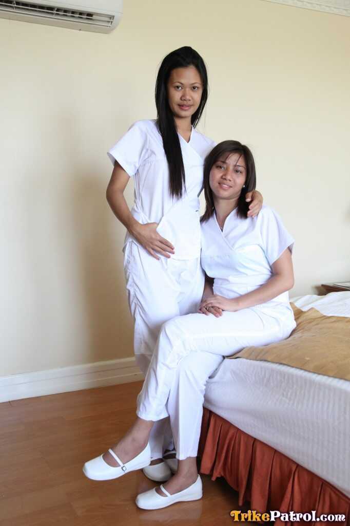 Lusty Filipina Nurses Joanna and Joy Pose on the Bed in Their White Uniforms As The Asian Beauties Explore Each Other&#039...
