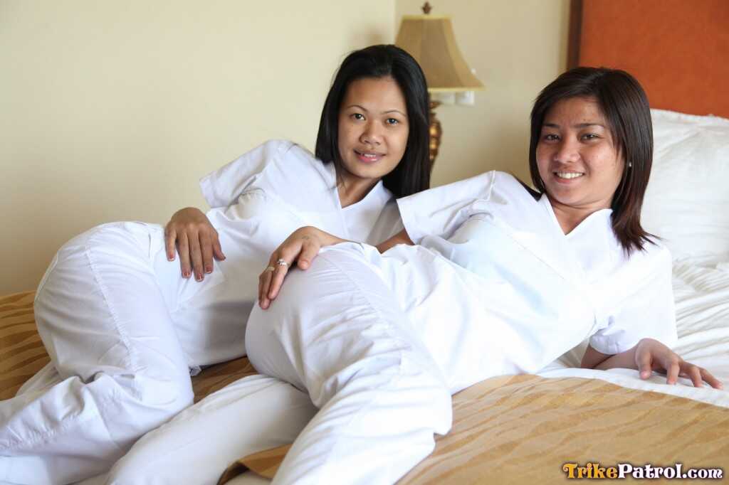 Lusty Filipina Nurses Joanna and Joy Pose on the Bed in Their White Uniforms As The Asian Beauties Explore Each Other&#039...