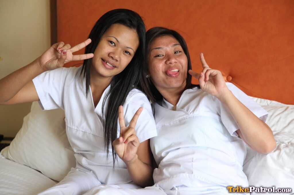 Lusty Filipina Nurses Joanna and Joy Pose on the Bed in Their White Uniforms As The Asian Beauties Explore Each Other&#039...