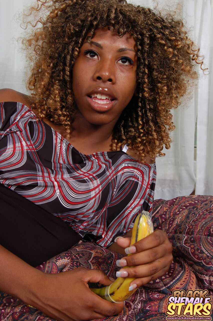Lusty curly-haired ebony shemale Kareema fucks herself with a banana, sucking and slurping on it like her life depends on ...