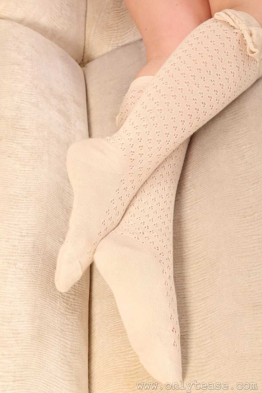 Sexy Holly Jade strips down to her pantyhose, teasing with her perky breasts on a pristine white sofa. - Holly Jade