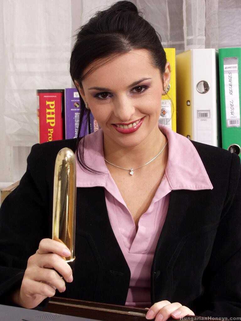 Sexy secretary Gaby Black's nipples and pussy get rubbed by a golden toy while she works hard in the office, leading ...