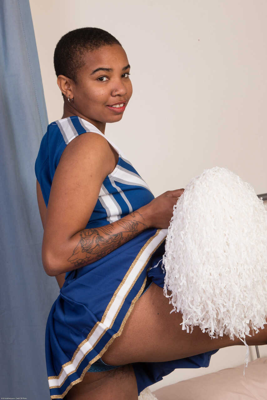 Shaved-headed ebony cheerleader Ryder Cruise undresses & shows her hairy holes