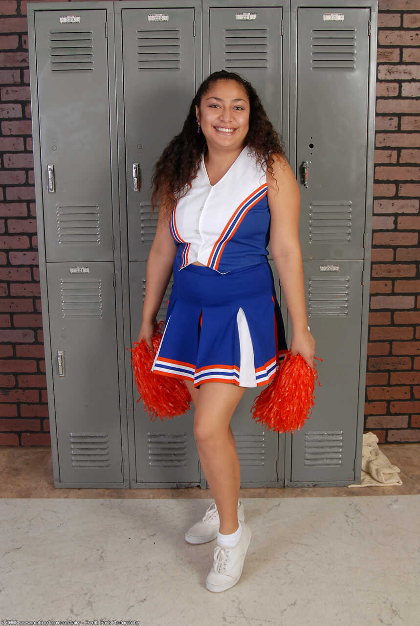 Curly haired cheerleader Reena shows off her big booty and hairy pussy - Reena