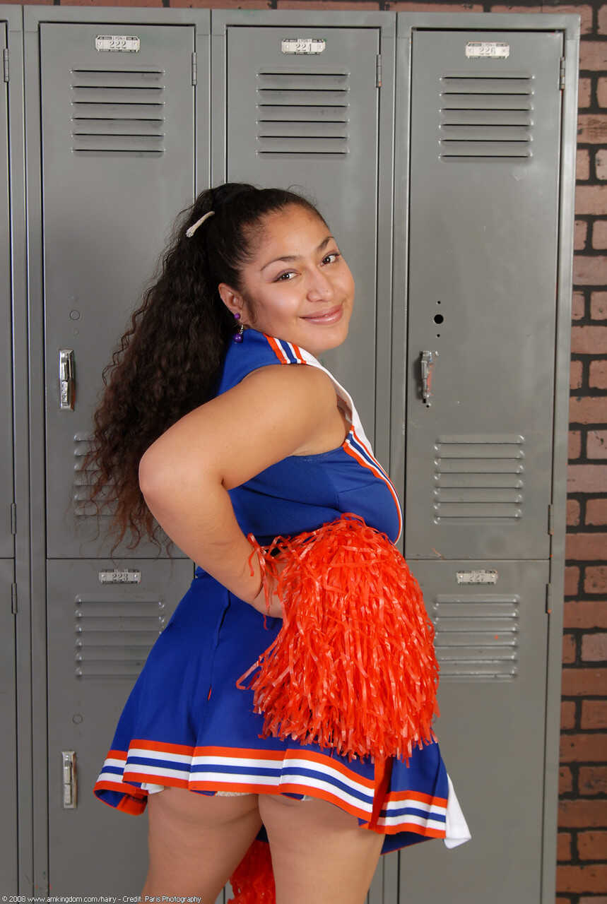 Curly haired cheerleader Reena shows off her big booty and hairy pussy - Reena