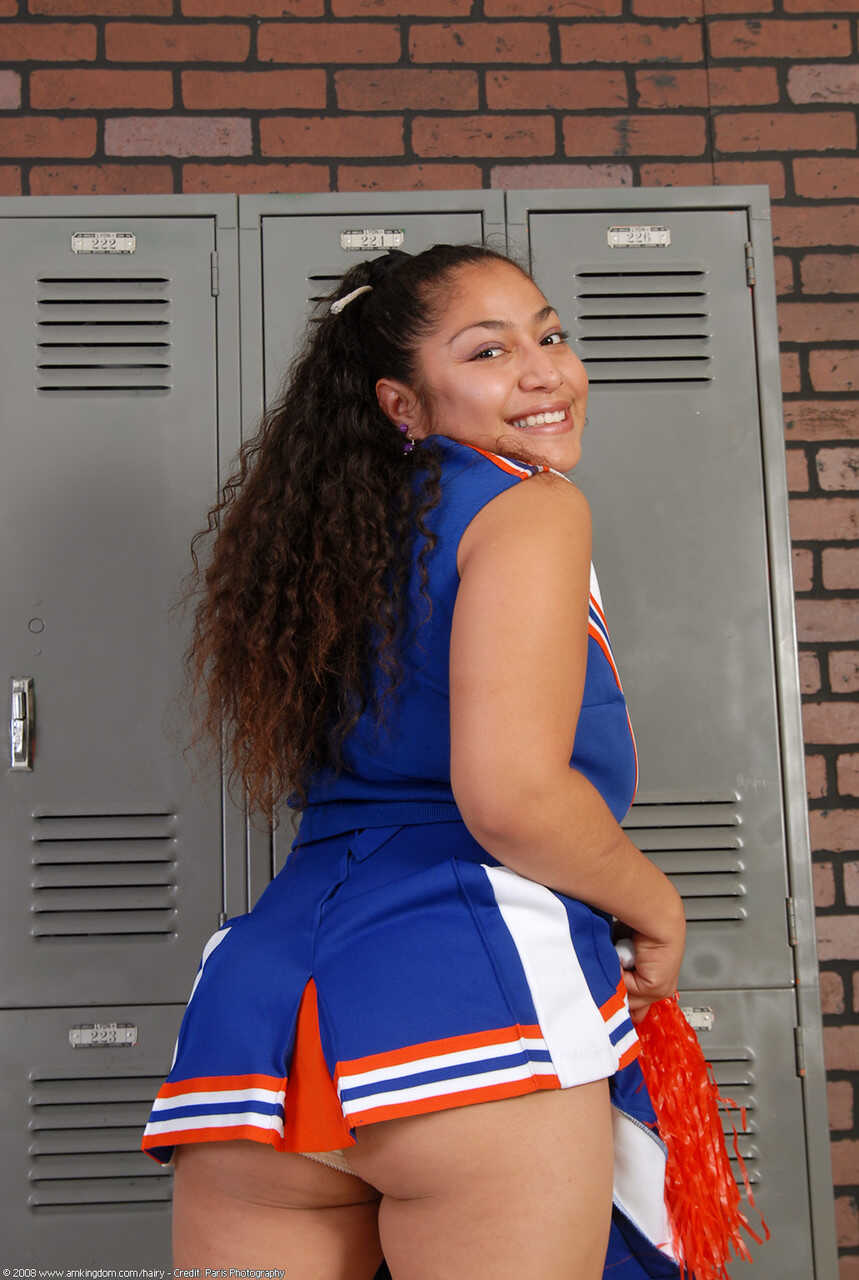 Curly haired cheerleader Reena shows off her big booty and hairy pussy - Reena