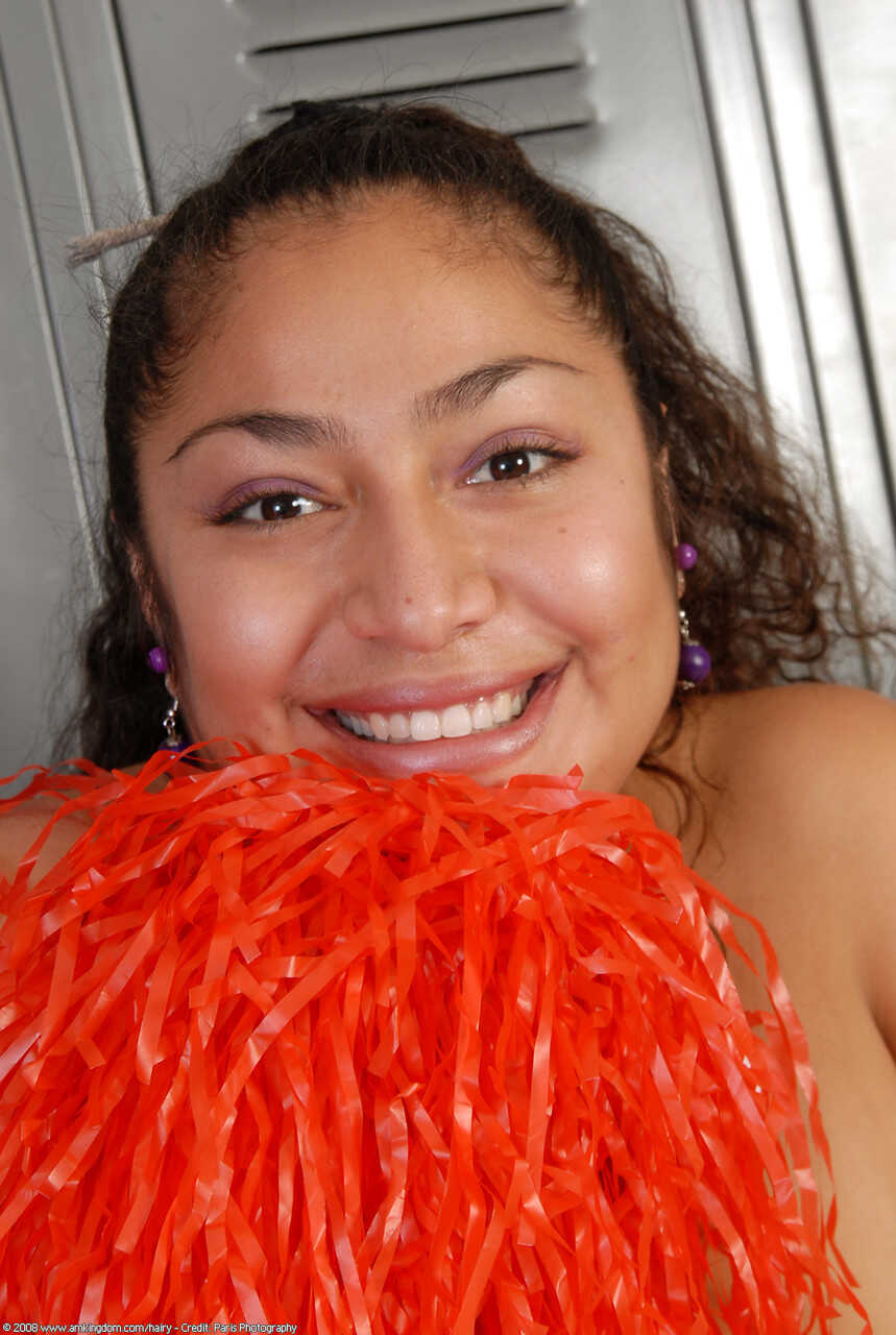 Curly haired cheerleader Reena shows off her big booty and hairy pussy - Reena