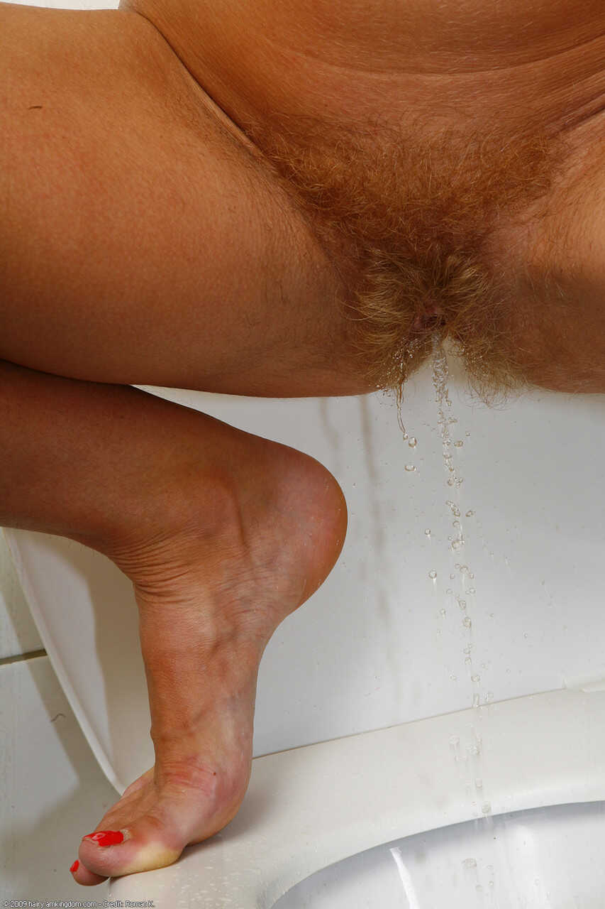 Mature blonde Yulja rubbing her hairy twat and pissing in a public toilet - Yulja